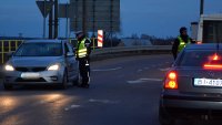 Dwóch policjantów sprawdza stan trzeźwości kierujących dwoma samochodami osobowymi, pora nocna