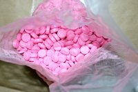 Torebka foliowa z zawartością tabletek koloru różowego.