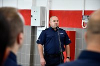 Komendant Wojewódzki Policji przemawia w budynku stacji diagnostycznej.