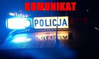 Radiowóz policyjny nocą, nad nim napis czerwonymi literami: KOMUNIKAT.