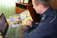 Policjant czyta dzieciom bajkę