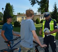 Policjant rozmawia z chłopakami na rowerach