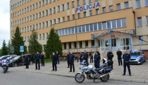 Policjanci stojący przed budynkiem Komendy Miejskiej Policji w Suwałkach