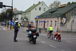 Policjant zabezpiecza przejazd rowerzystów