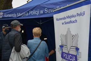 stoisko profilaktyczne Komendy Miejskiej Policji w Suwałkach i dwie osoby