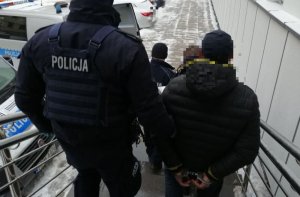 Policjanci prowadzą osoby zatrzymane