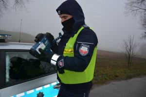 Policjant trzyma miernik prędkosci