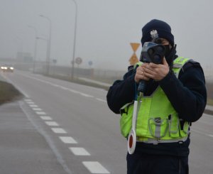 Policjant mierzy prędkość z jaką poruszają się kierujący