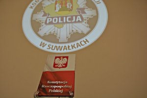 Konstytucja RP na tle ściany z logo KMP Suwałki