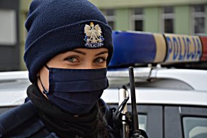 Policjantka w zimowej czapce przy radiowozie