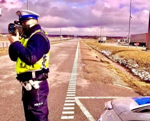 Policjant WRD mierzy prędkość, z jaką poruszają się pojazdy po drodze