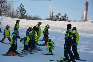 Policjant z dziećmi na nartach