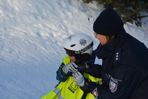 dziecko na nartach z policjantką