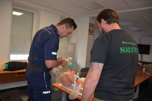 policjant  i ratownik medyczny wykonują szkolenie z zakresu pierwszej pomocy