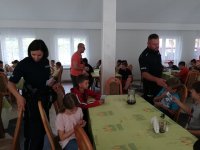 Policjanci podczas spotkania z dziećmi na letnim wypoczynku.