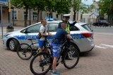 Policjant RD w umundurowaniu służbowym rozmawia z dwoma młodymi rowerzystami