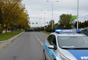 Radiowóz policyjny, w tle rowerzyści