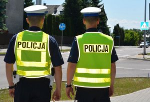 Policjanci w kamizelkach odblaskowych z napisem POLICJA