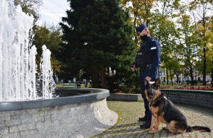 Przewodnik psa służbowego w umundurowaniu ćwiczebnym z psem służbowym w parku