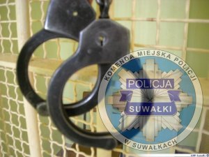kajdanki i logo Policji w Suwałkach