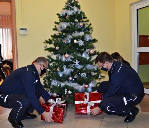 Policjanci i pracownicy KMP Suwałki kładą pod choinką &quot;Paczki Bożonarodzeniowe&quot;