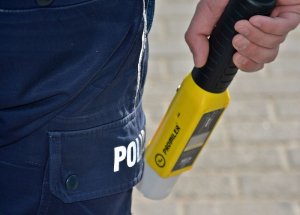 fragment nogi ręki policjanta w rękach trzyma promiler
