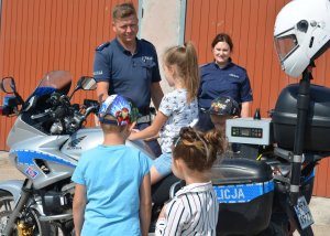 Policjant pokazuje dzieciom motocykl słuzbowy