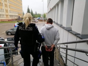 policjantka prowadzi zatrzymanego