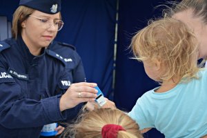 Policjantka stawia dziecku pieczątkę na rączce