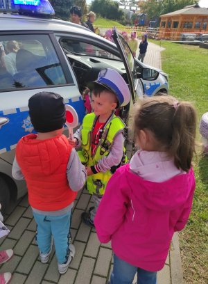 Dzieci na tle radiowozu policyjnego