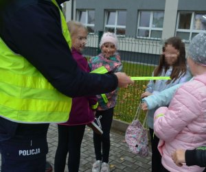 Policjant wręcza odblask