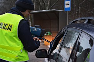 Policjant WRD zatrzymał pojazd do kontroli, pokazuje kierowcy urządzenie, na którym widać prędkość, z jaką jechał