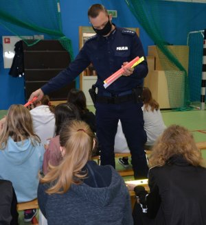 Policjant rozdaje dzieciom odblaski