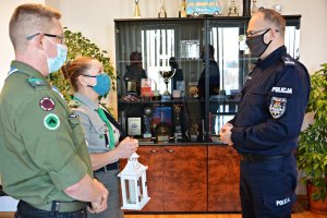 Harcerze przekazują Komendantowi Miejskiemu Policji w Suwałkach Betlejemskie Światło Pokoju