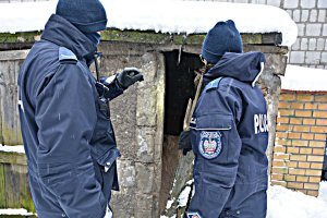 Policjanci zaglądają do pustostanu- aura zimowa