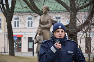 Dzielnicowa pełni służbę w swoim rejonie, w tle pomnik Marii Konopnickiej