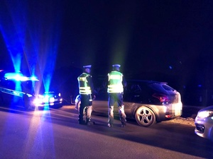 Policjanci kontrolują samochód, noc