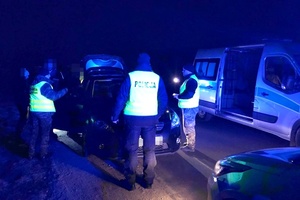 Policjanci kontrolują samochód, noc, działania wspólnie ze strażnikami granicznymi