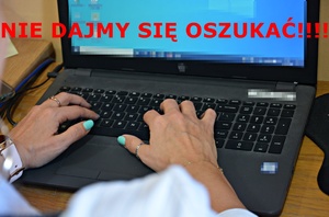 Dłonie kobiety na klawiaturze laptopa, nad nimi czerwony napis: Nie dajmy się oszukać!!!