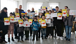 Zdjęcie grupowe, dzieci, doroęli trzymają dyplomy i swoje prace konkursowe