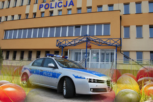 Radiowóz na tle budynku KMP Suwałki, wokół kolorowe jaja- pisanki