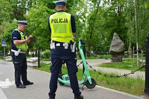 Policjanci kontrolują osobę poruszającą się hulajnogą