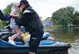 Policyjne skutery wodne, policjanci pomagają dzieciom wsiąść do skutera
