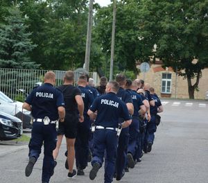 Spojrzenie od tyłu na biegnącą kolumnę policjantów