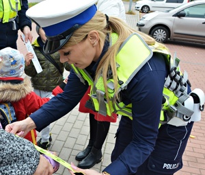 Policjanci przekazują dzieciom elementy odblaskowe