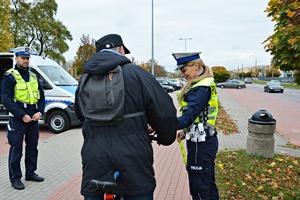 Policjanci przekazują rowerzyście elementy odblaskowe