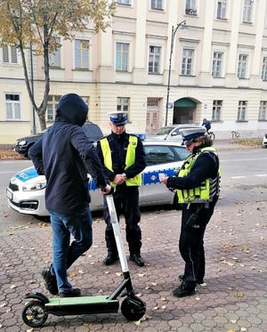 Policjanci kontrolują mężczyznę z hulajnogą