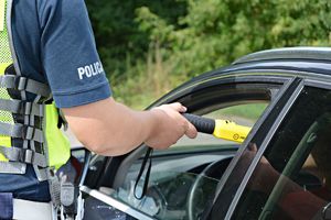 Policjant bada trzeźwość kierowcy