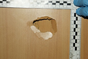 Uszkodzone brązowe drzwi z metryczką