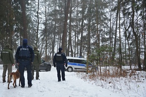Policjanci i strażnicy WPN w zaśnieżonym lesie